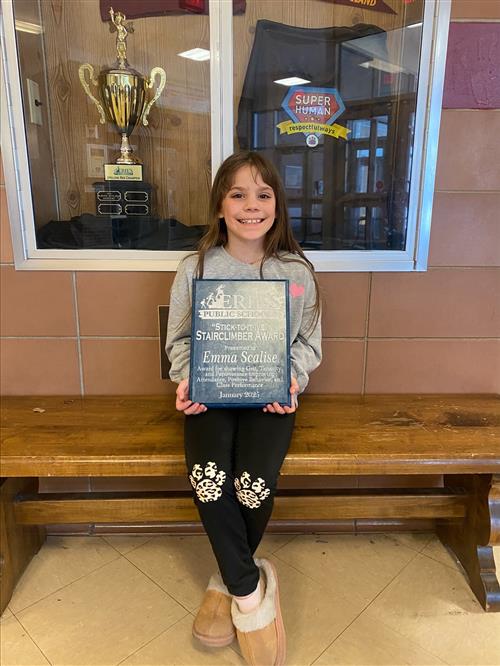 Emma Scalise, Grover Cleveland's Stairclimber recipient for the month of January, poses with her plaque.